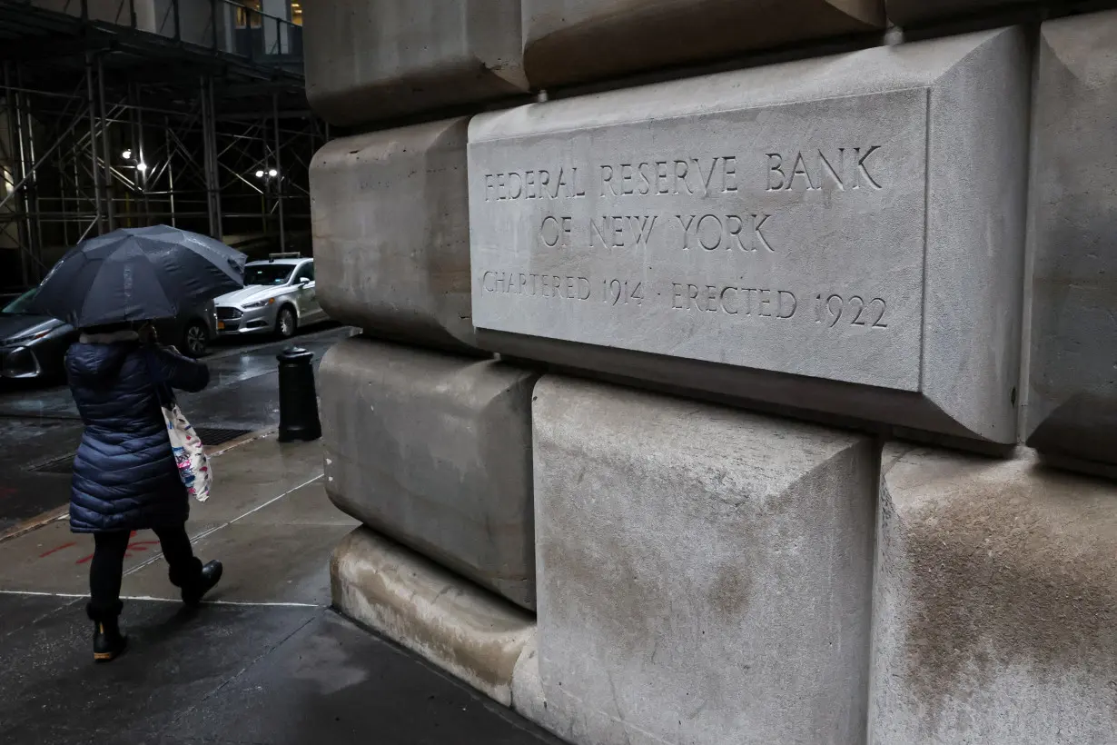 A woman passes by The Federal Reserve Bank of New York in New York