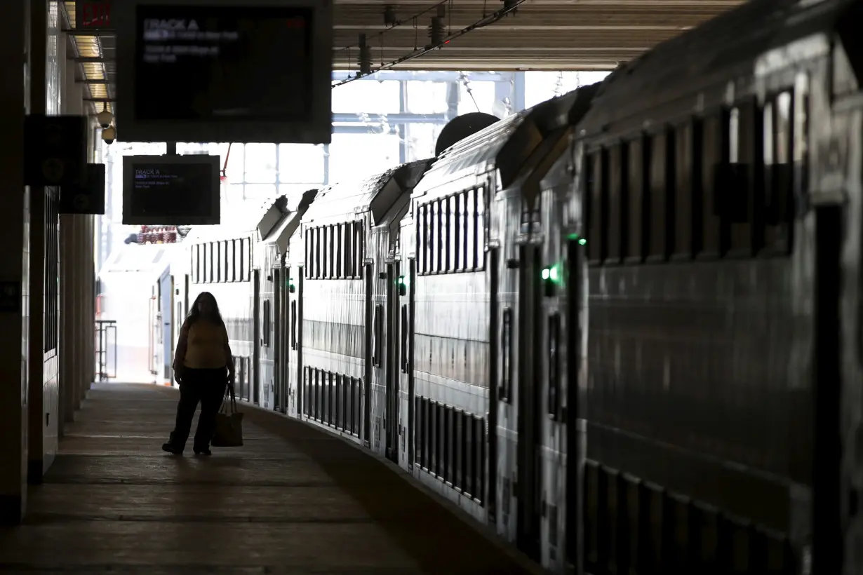 FILE PHOTO: A commuter stands on the platform as a New Jersey Transit commuter train bound for New York City arrives at the Secaucus Junction station in Secaucus