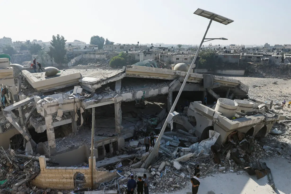 Palestinians inspect the site of an Israeli strike on a mosque in Khan Younis in the southern Gaza Strip