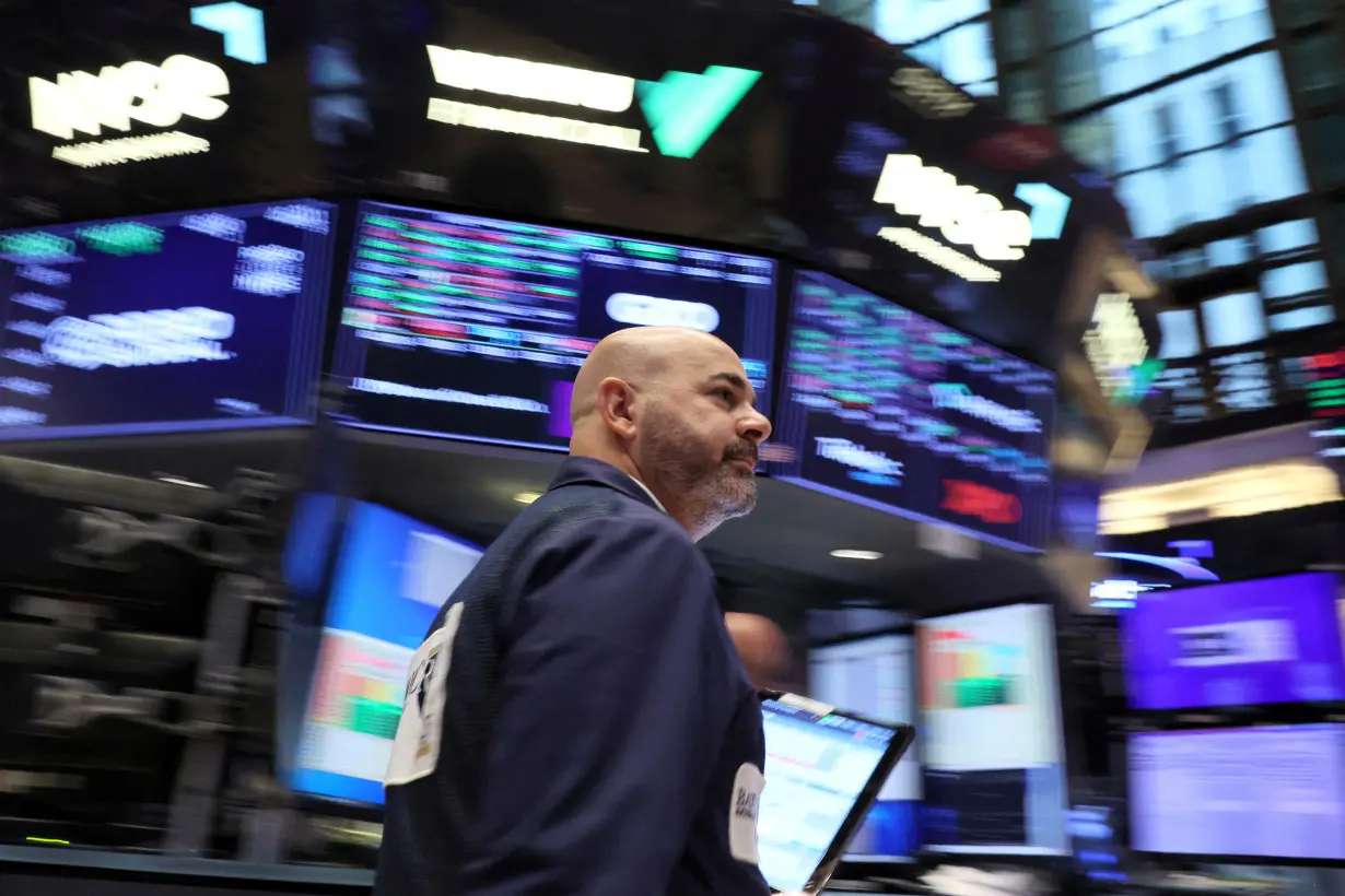 FILE PHOTO: Traders work on the floor of the NYSE in New York