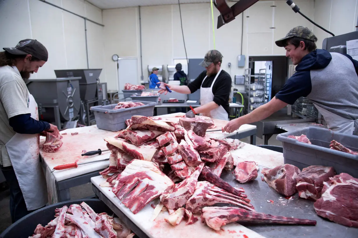 Employees cut fresh beef