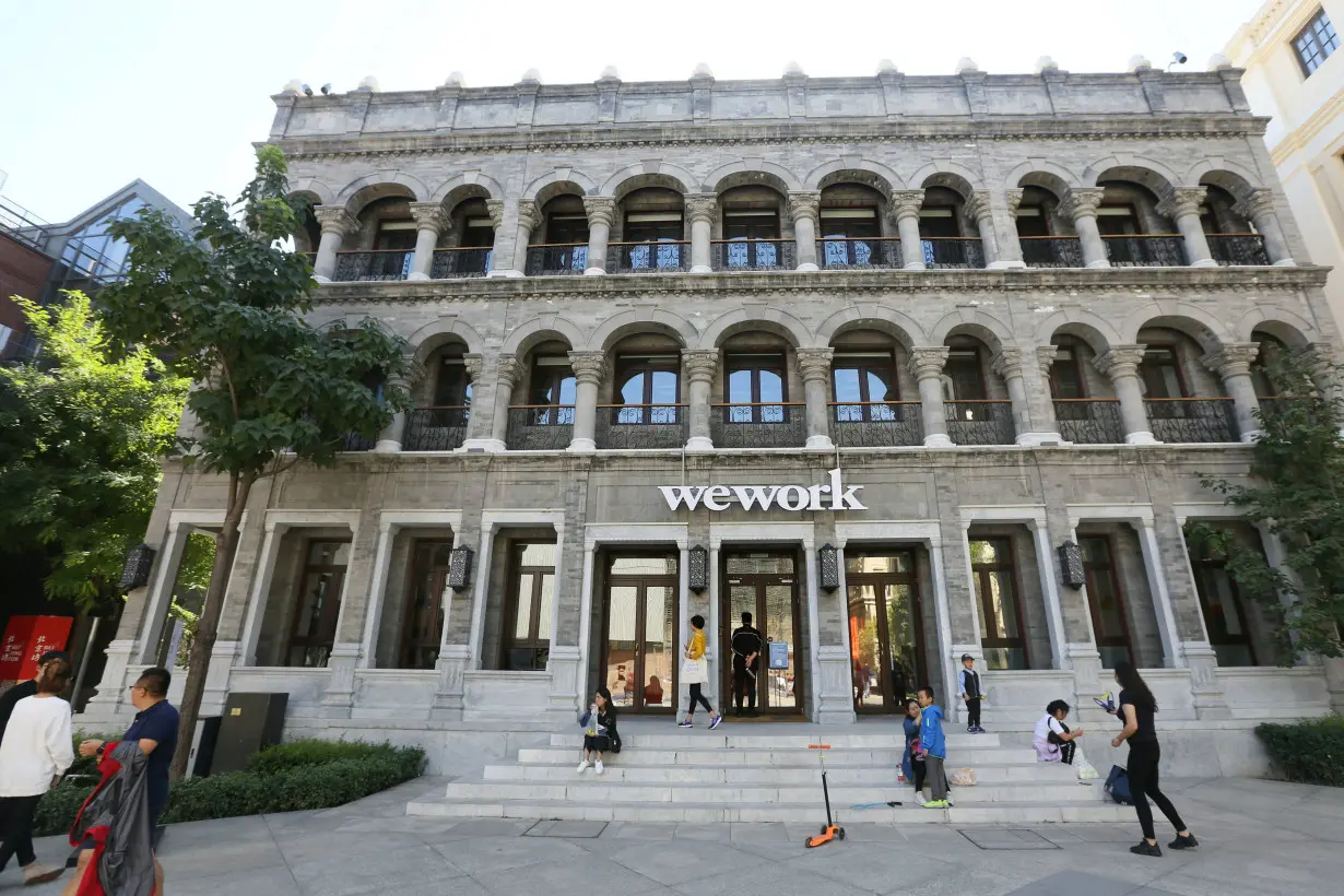 People are seen outside the building of Wework's co-working space during the National Day Golden Week holiday, in central Beijing