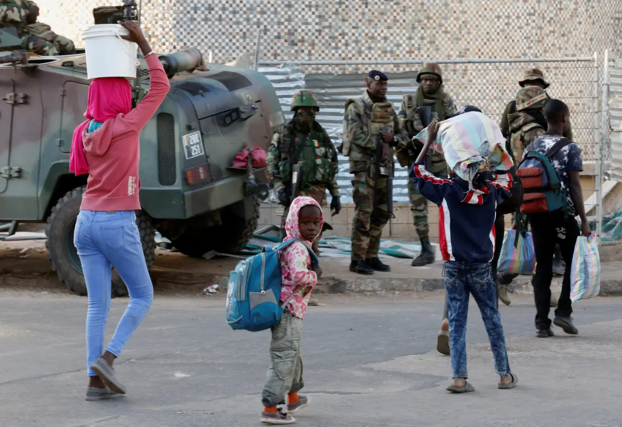 Children walk past regional ECOWAS troops in Banjul