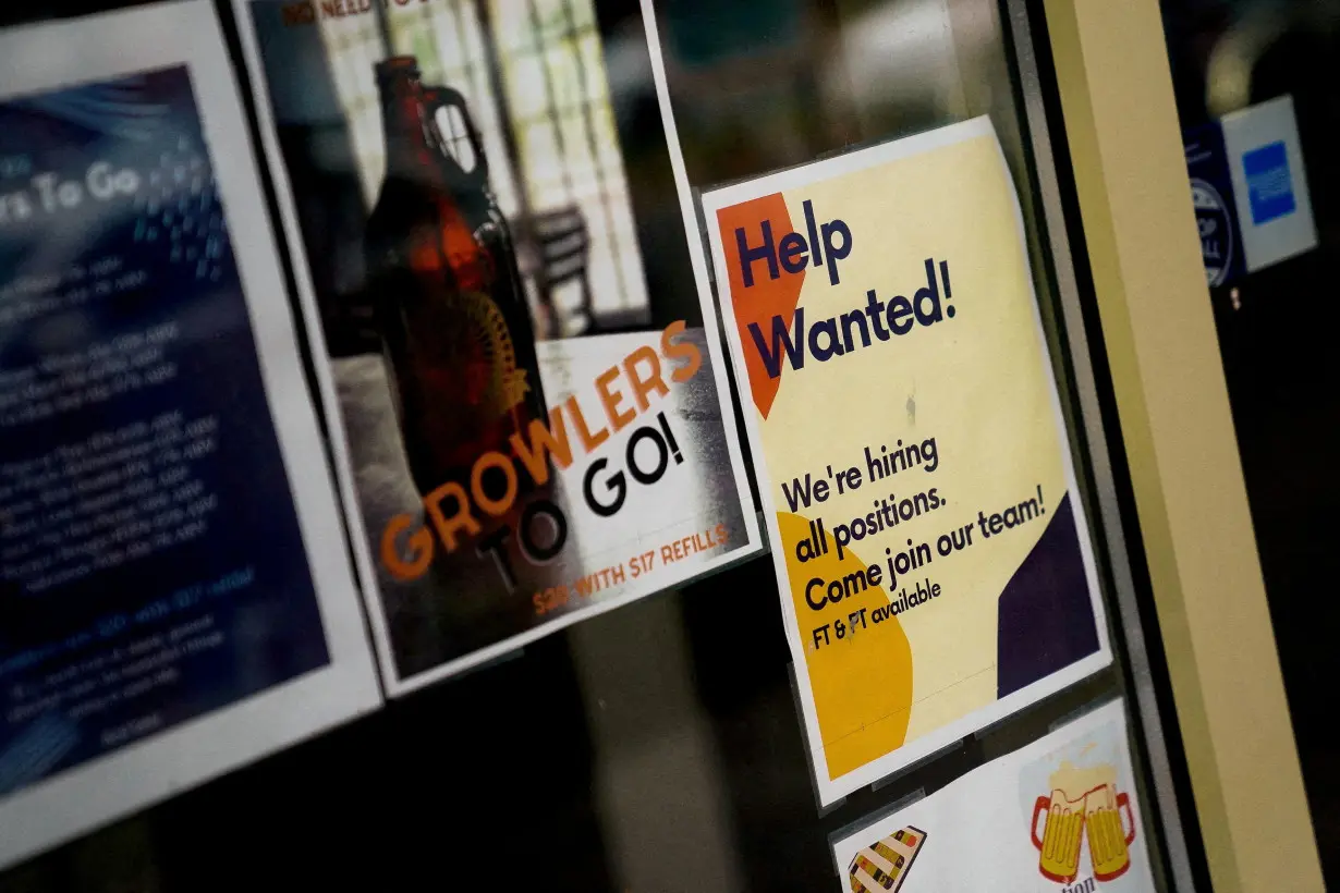 FILE PHOTO: An employee hiring sign is seen in a window of a business in Arlington