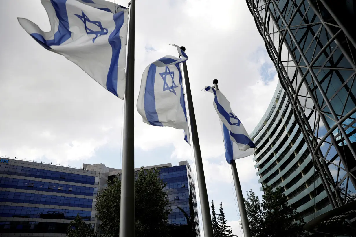 FILE PHOTO: Israeli national flags flutter near office towers at a business park in Petah Tikva, Israel