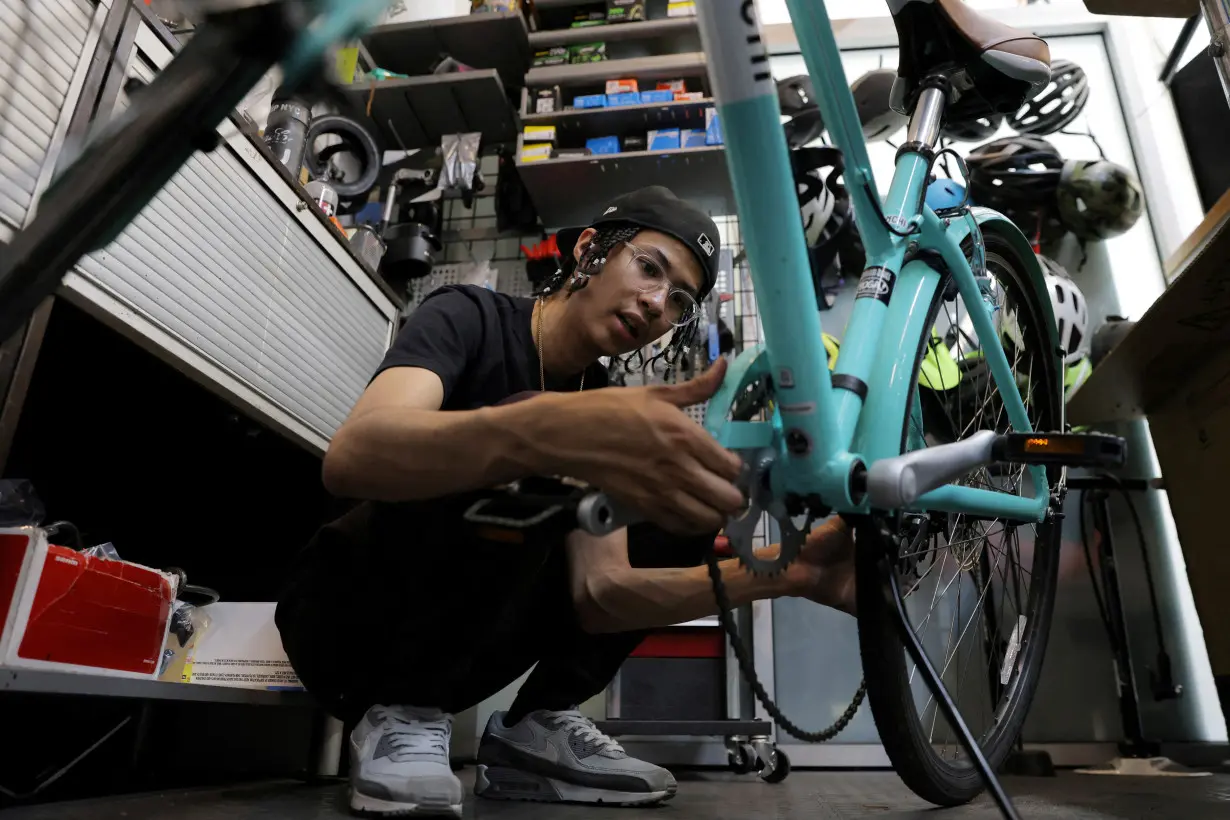 A worker repairs a bicycle in the Toga Bike Shop in Manhattan, New York City