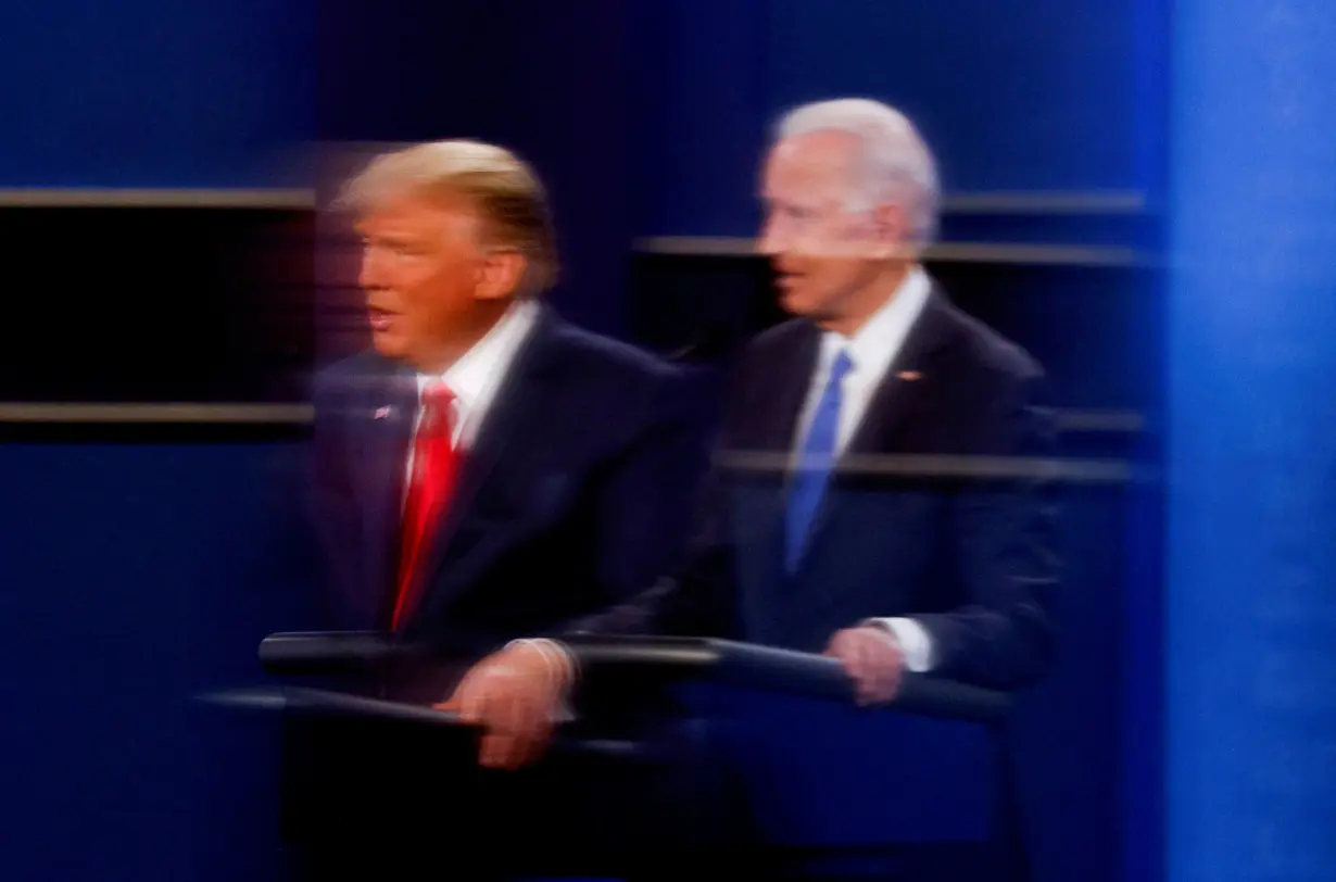 FILE PHOTO: U.S. President Donald Trump and Democratic presidential nominee Joe Biden are reflected in the plexiglass in Nashville