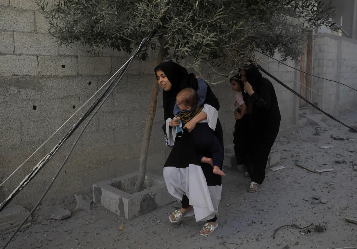 Palestinians evacuate the site of Israeli strikes on houses in Maghazi refugee camp