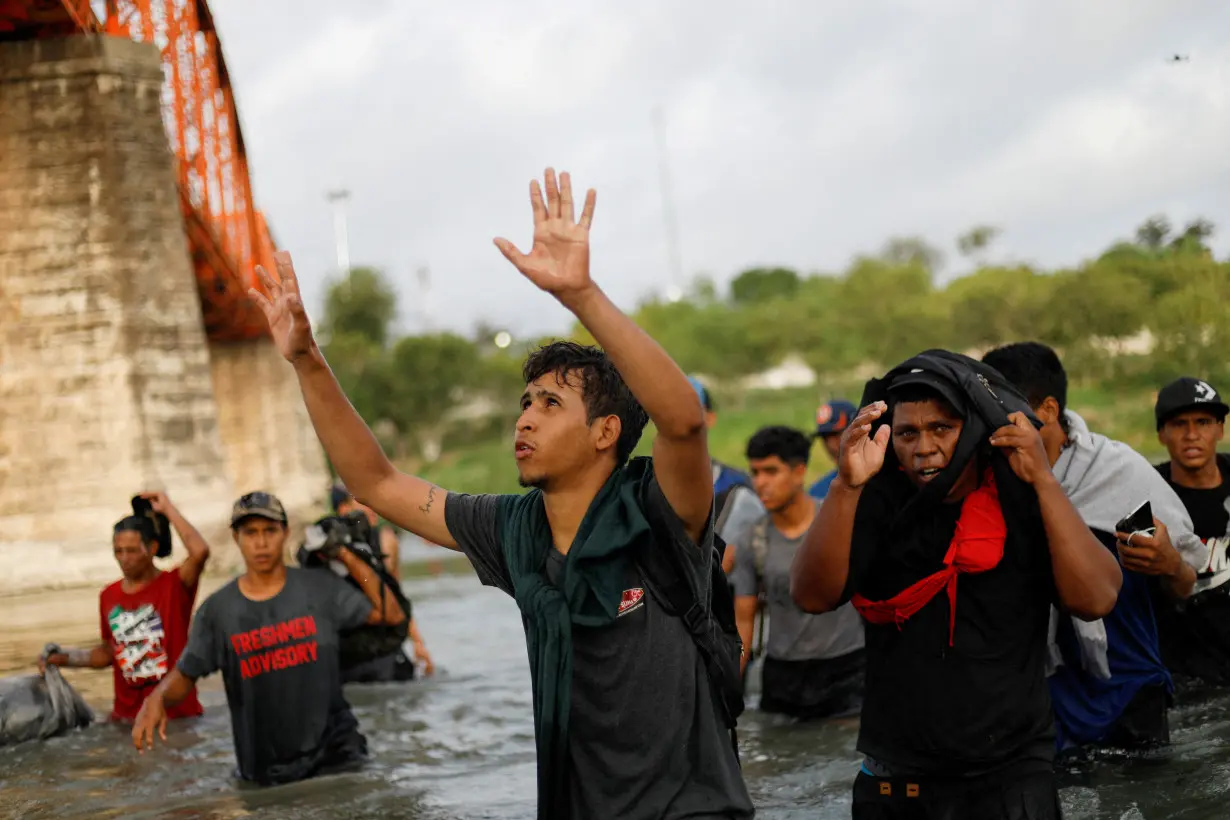 FILE PHOTO: Migrants walk through the Rio Grande river seeking asylum into the U.S., as seen from Piedras Negras