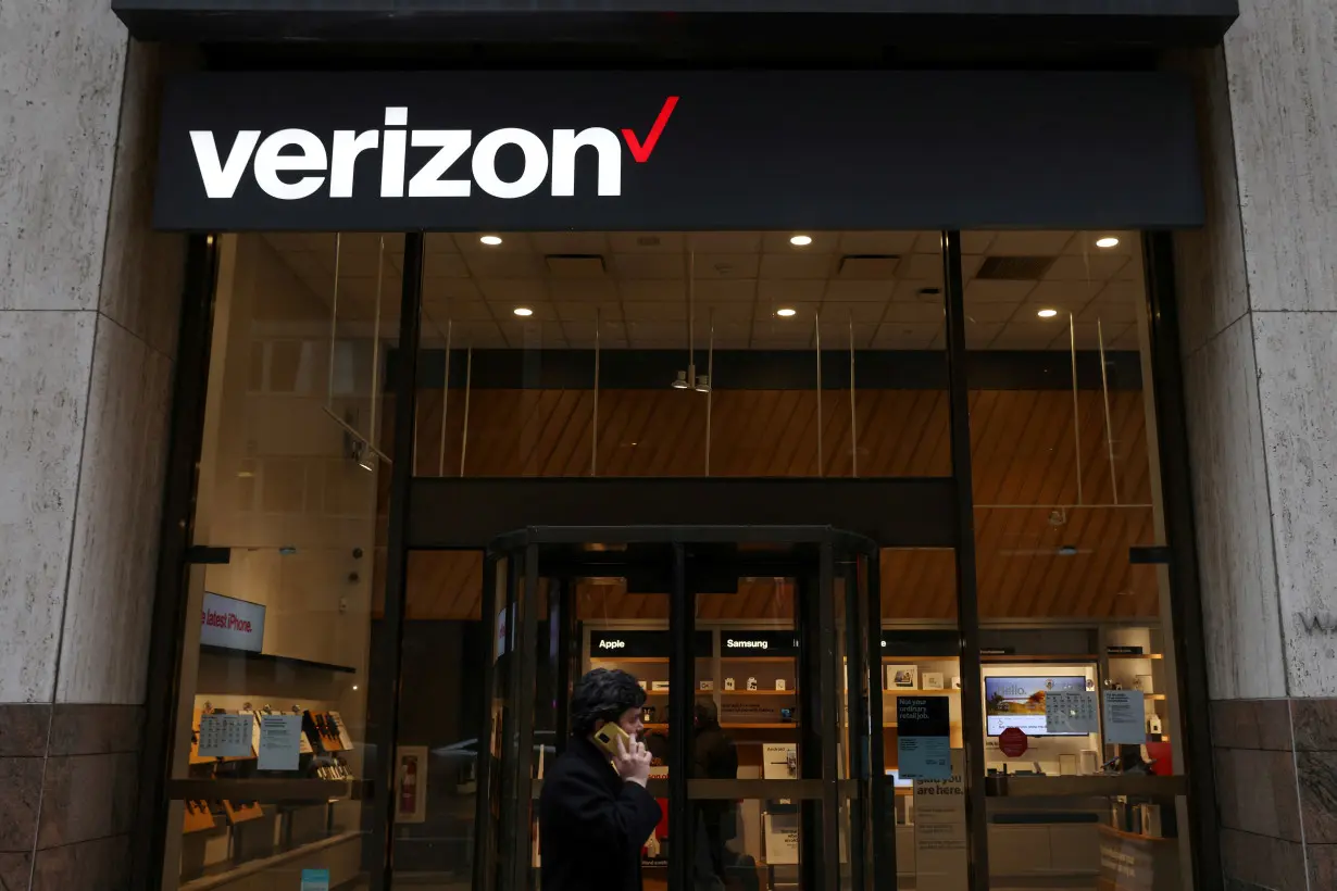 FILE PHOTO: A person walks by a Verizon store in Manhattan, New York City