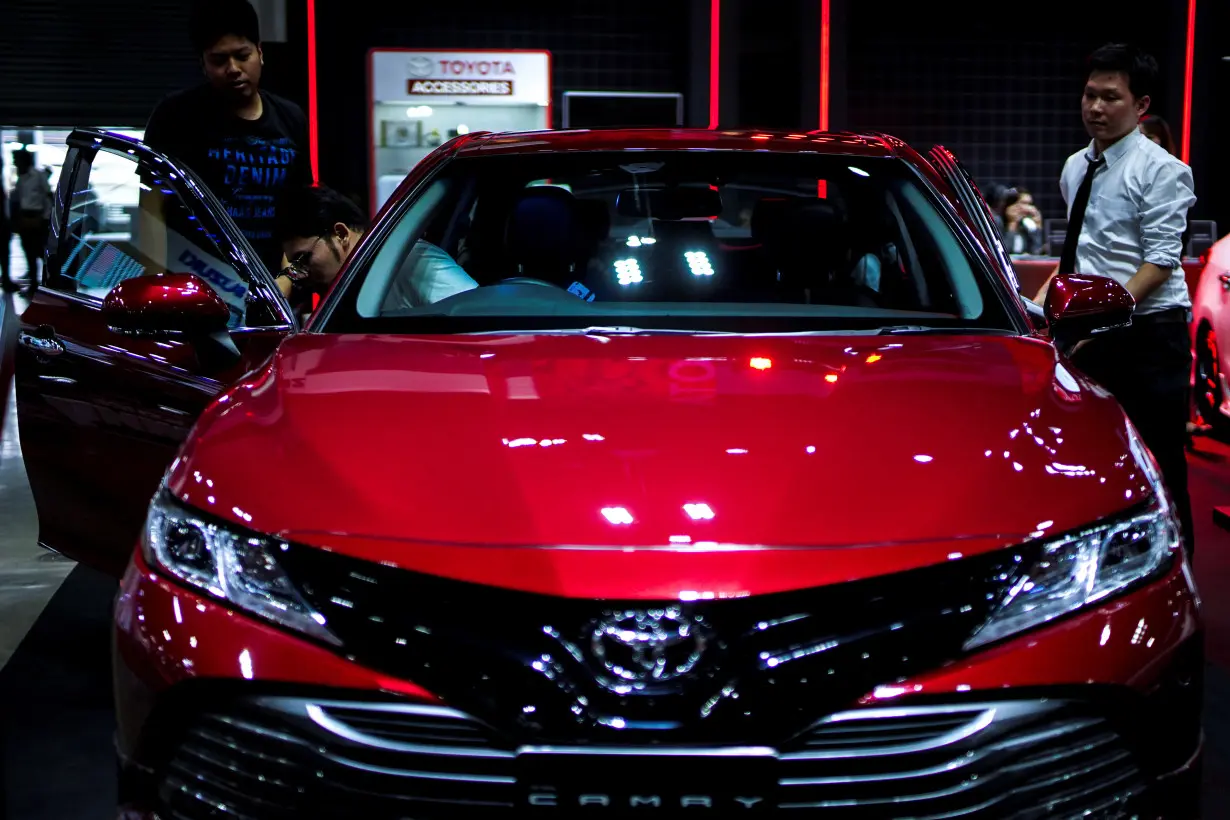 Visitors look at a Toyota Camry car during the Bangkok Auto Salon 2019 in Bangkok