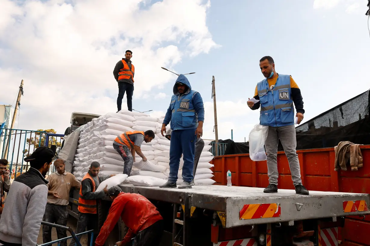 Palestinians receive flour bags distributed by UNRWA in Rafah