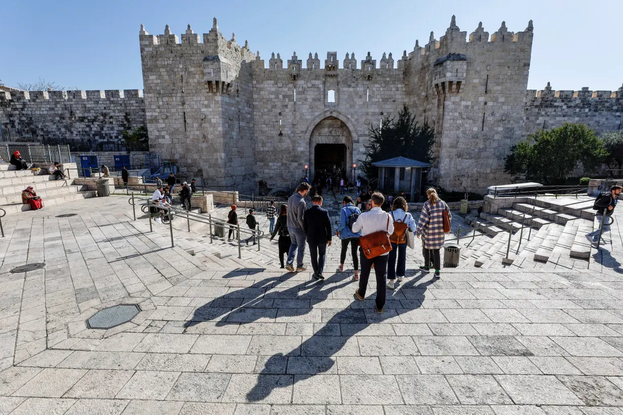 A group of tourists descends the stairs leading to the Damascus Gate, in Jerusalem's Old City