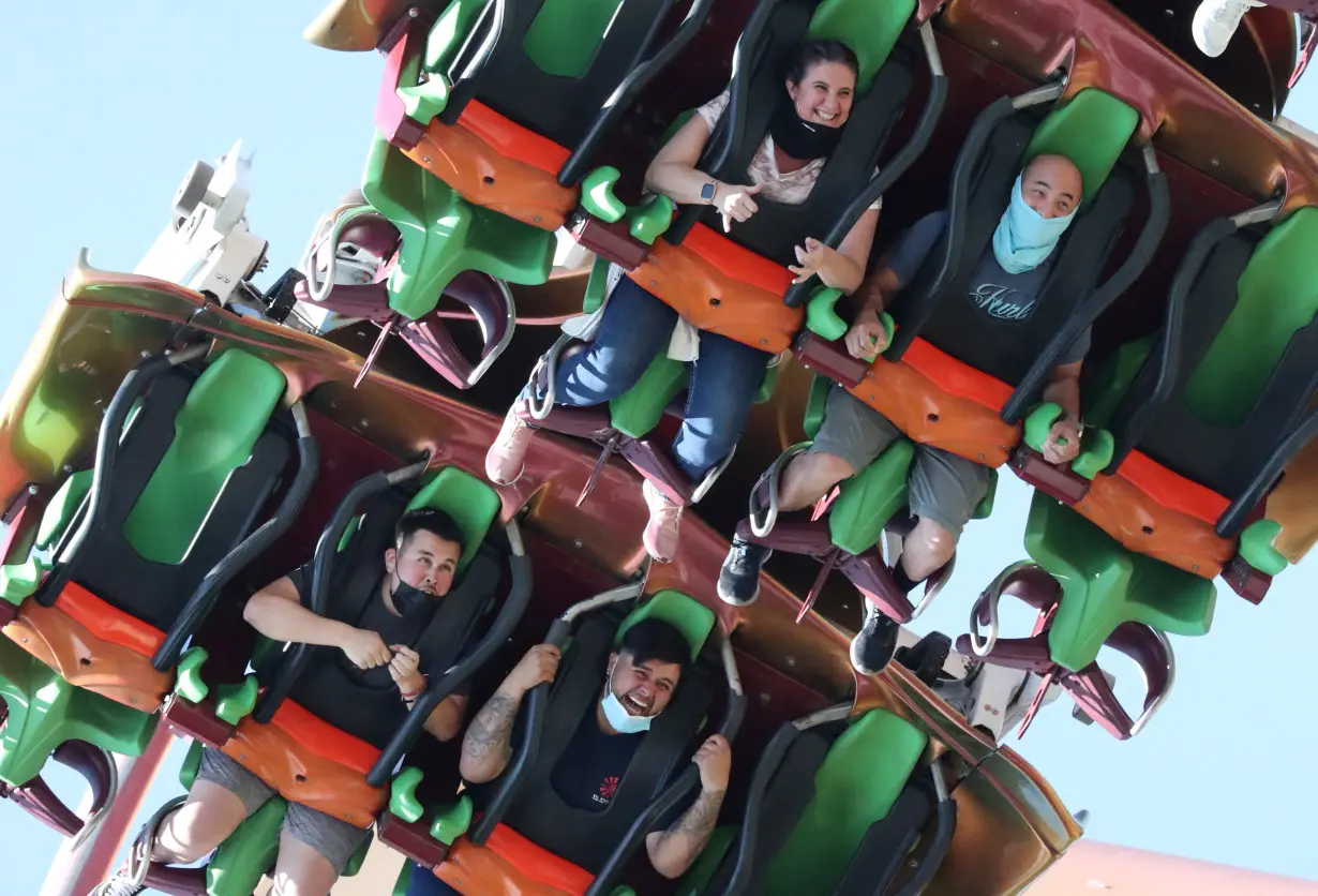 People ride a roller coaster at Six Flags Magic Mountain amusement park on the first day of opening, as the coronavirus disease (COVID-19) continues, in Valencia