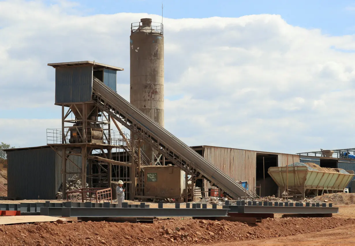 FILE PHOTO: A worker checks their mobile phone at Prospect Lithium mine and processing plant in Goromonzi