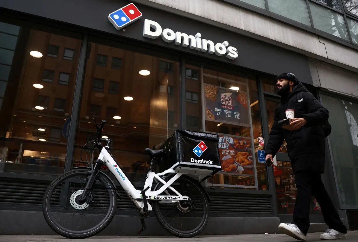 FILE PHOTO: A person walks past a Domino's pizza restuarant in London