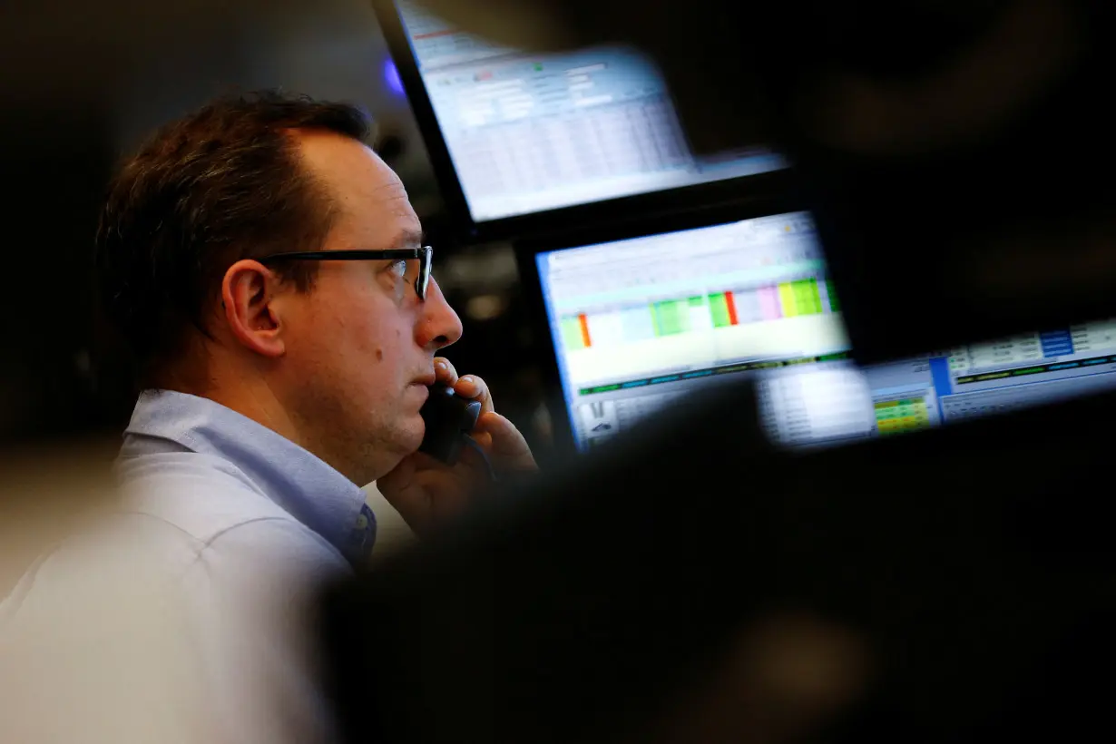 FILE PHOTO: Trader works at his desk at the stock exchange in Frankfurt