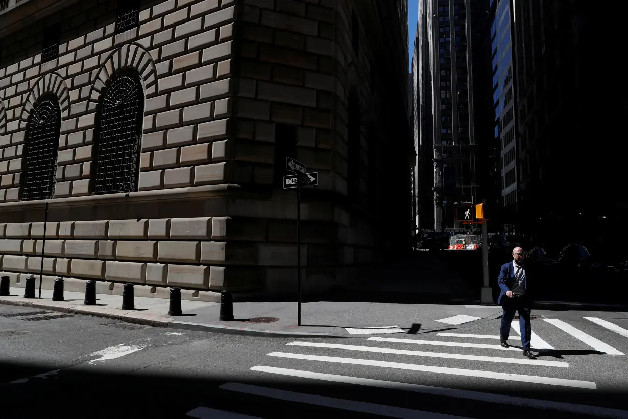 A man walks by the Federal Reserve Bank of New York Building in New York City