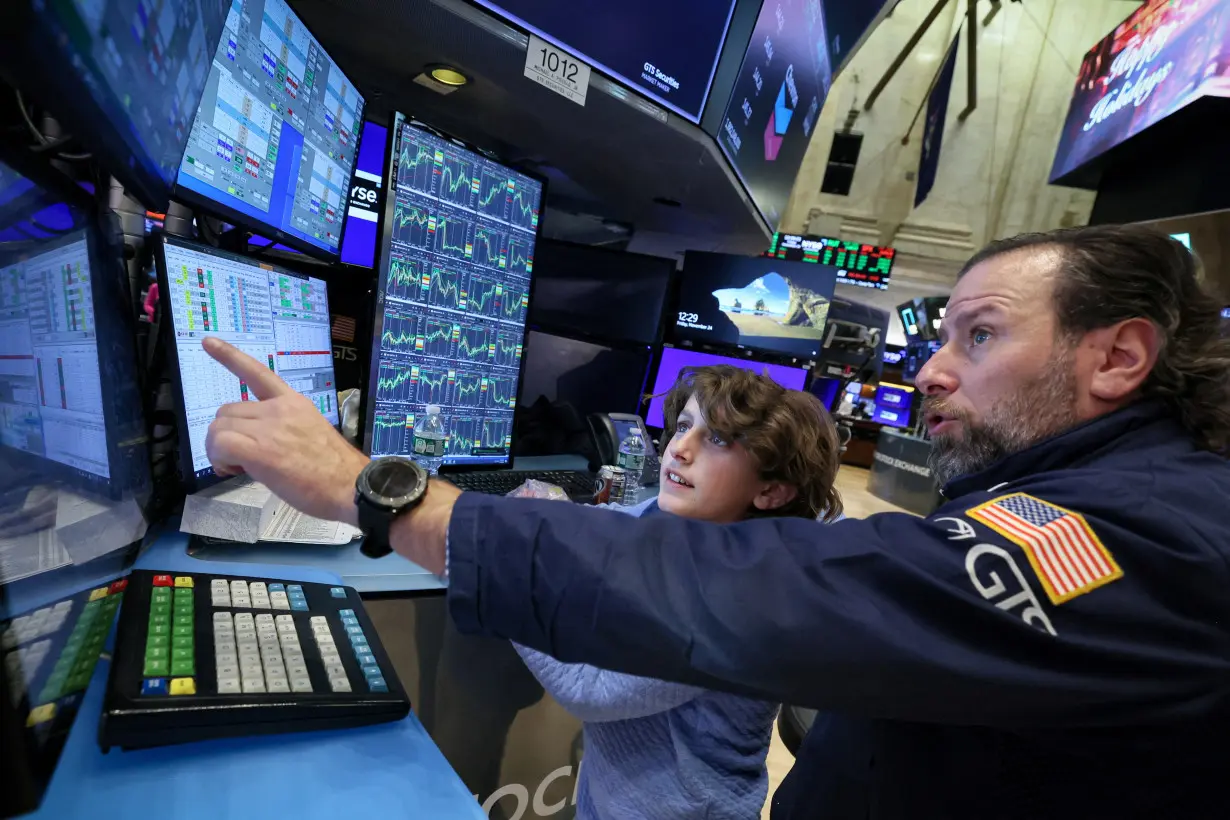 FILE PHOTO: Traders and kids work on the floor of the NYSE in New York