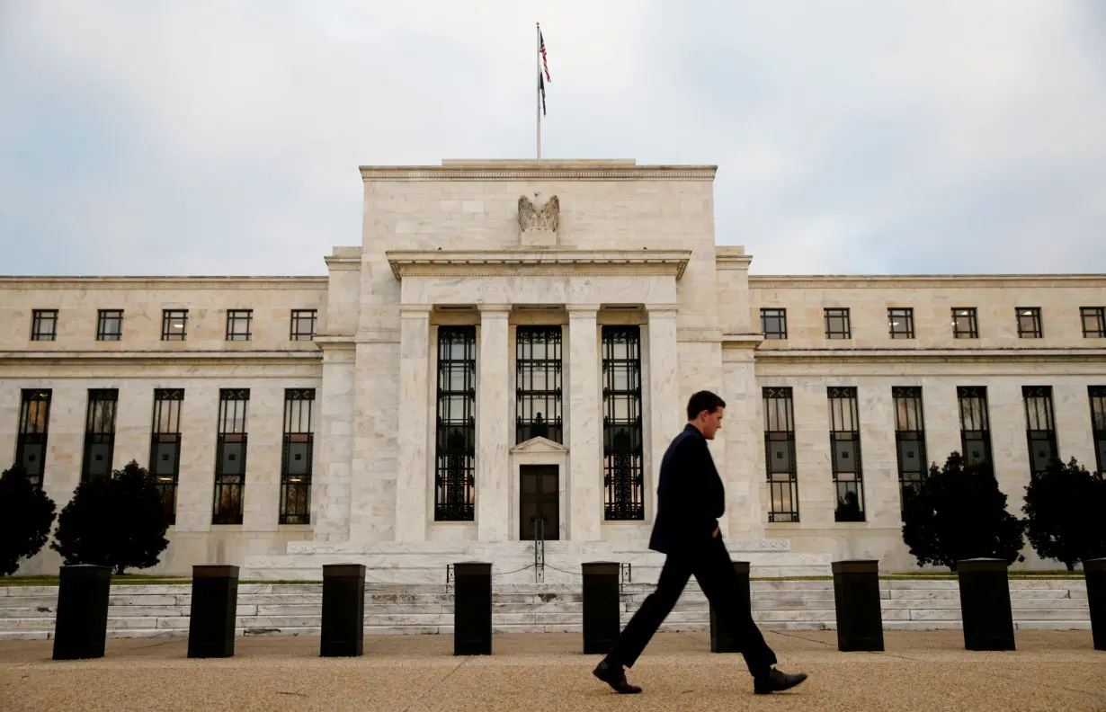 FILE PHOTO: A man walks past the Federal Reserve Bank in Washington DC