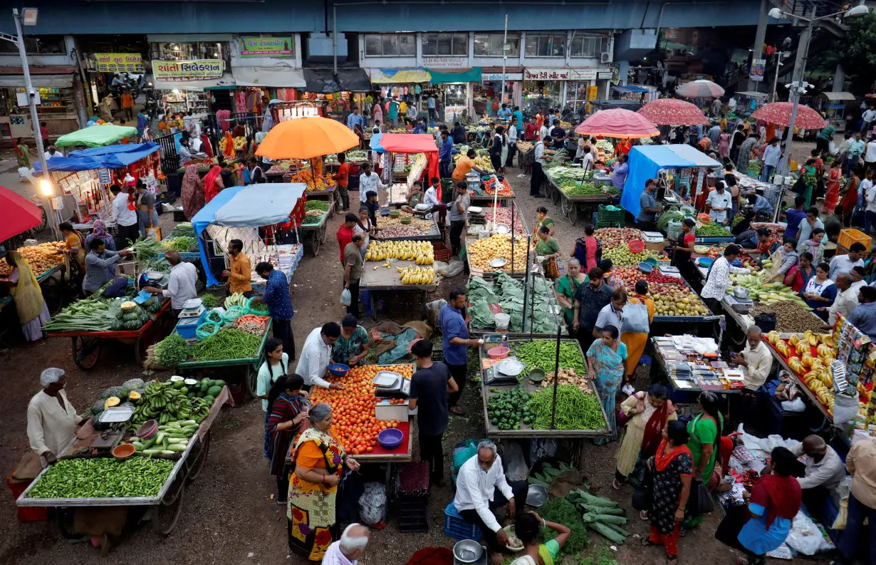 FILE PHOTO: Customers buy fruits and vegetables at an open air evening market in Ahmedabad