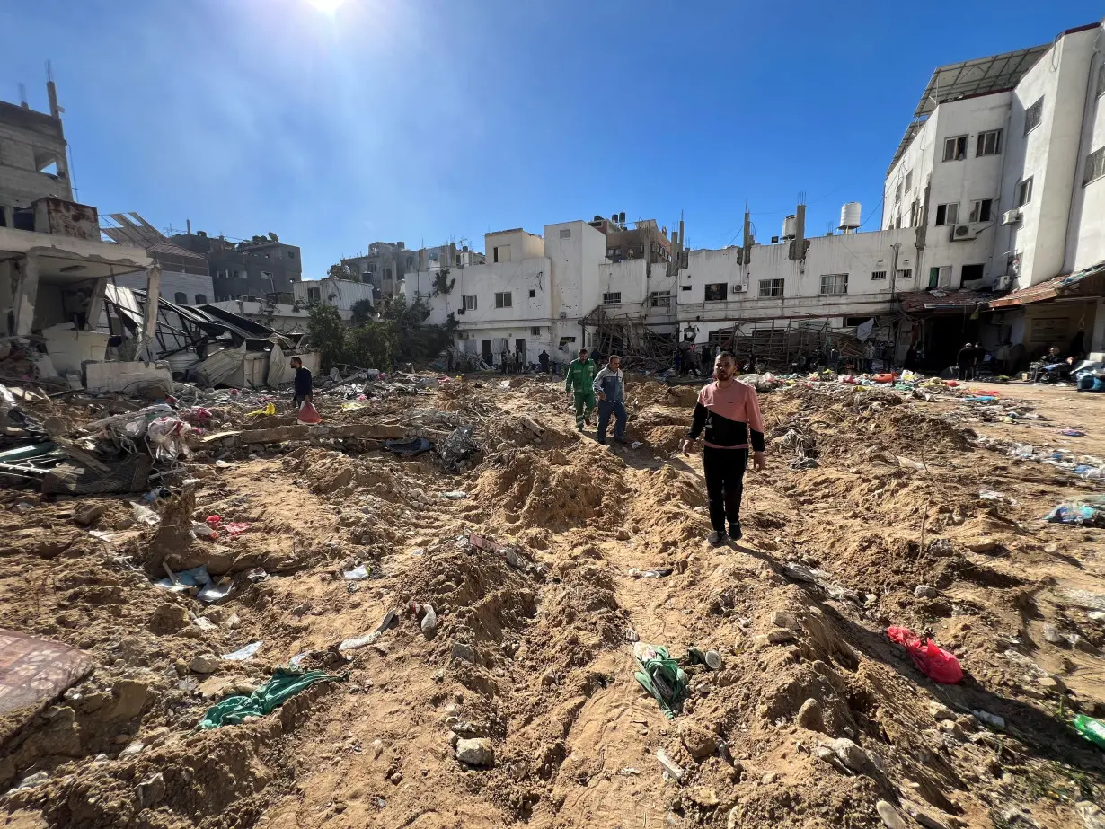 Palestinians inspect damages following an Israeli raid at Kamal Adwan hospital in the northern Gaza Strip