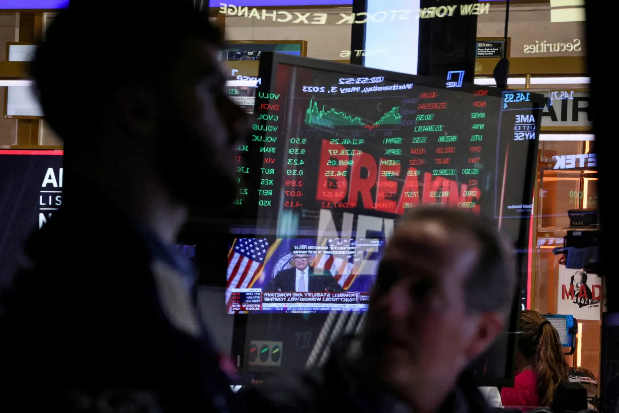 FILE PHOTO: Traders react as Federal Reserve Chair Jerome Powell is seen delivering remarks on a screen on the floor of the NYSE in New York