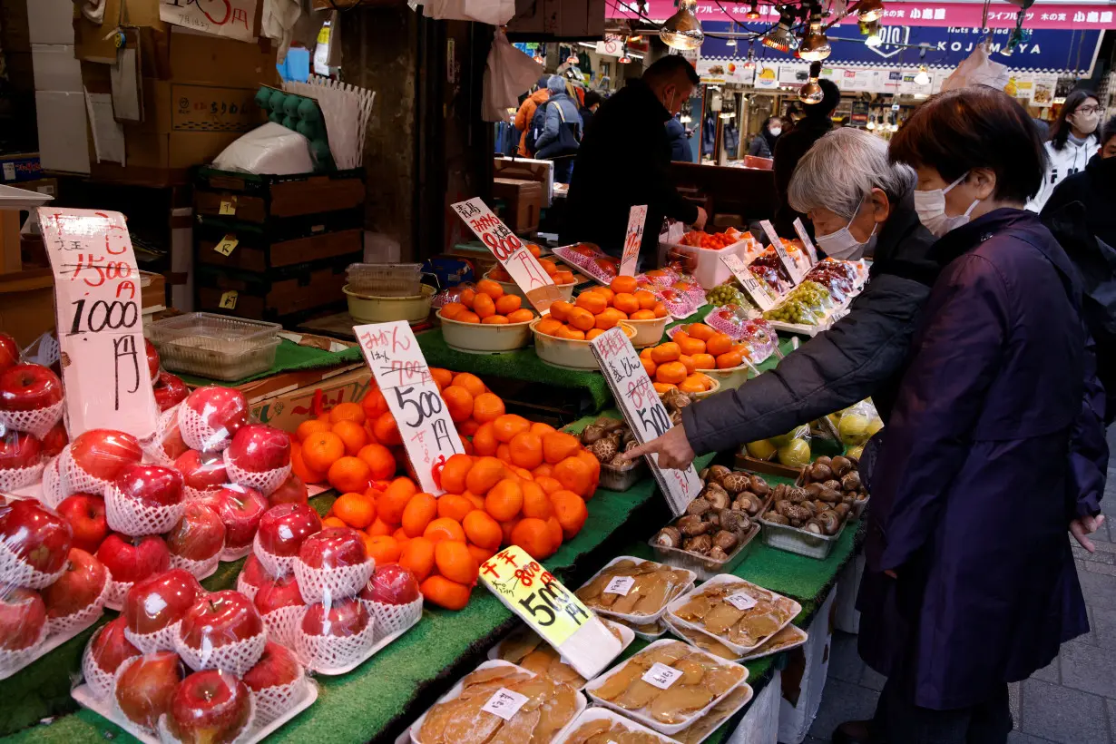 FILE PHOTO: People shop daily nessesities at a market in Tokyo