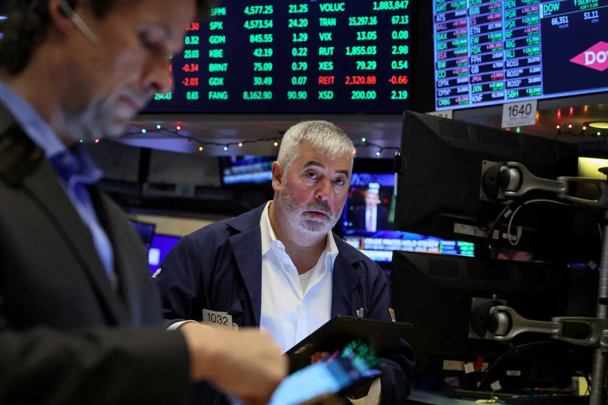 FILE PHOTO: Traders work on the floor of the NYSE in New York