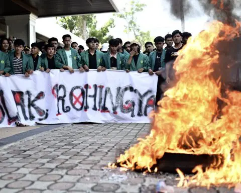 Indonesia's navy pushes a boat suspected of carrying Rohingya refugees out of its waters