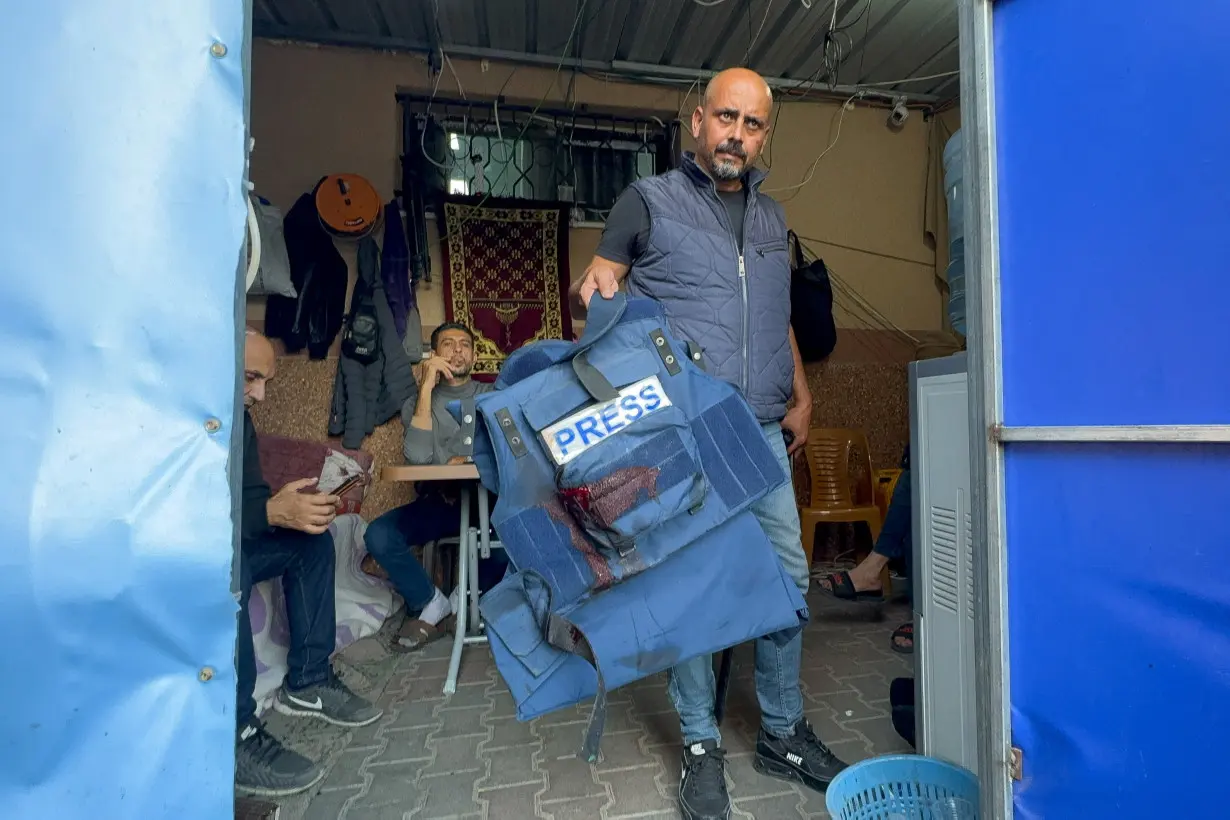 A man holds the flak jacket which belongs to Al Jazeera journalist Wael Al-Dahdouh, in Khan Younis