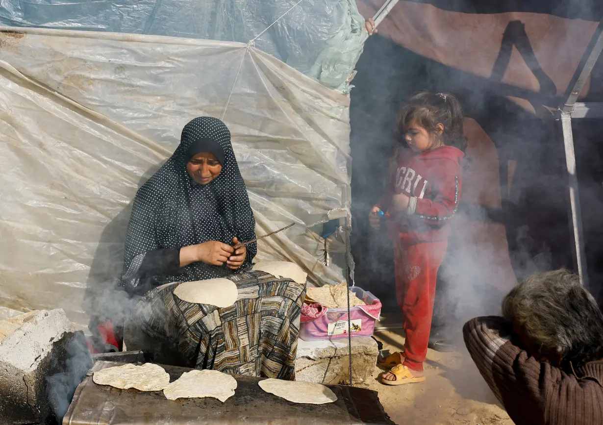 Displaced Palestinians, who fled their houses due to Israeli strikes, shelter in a tent camp near the border with Egypt, in Rafah