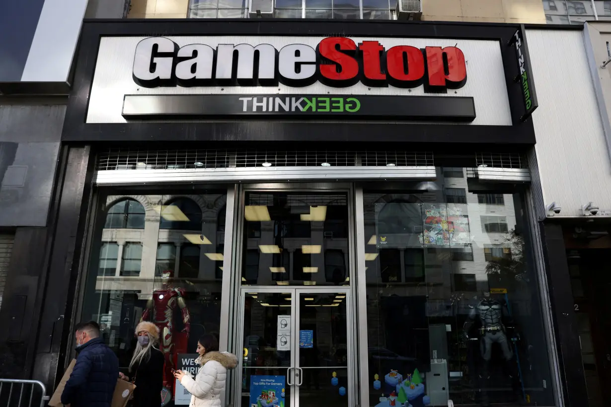 FILE PHOTO: People walk by a GameStop in Manhattan, New York