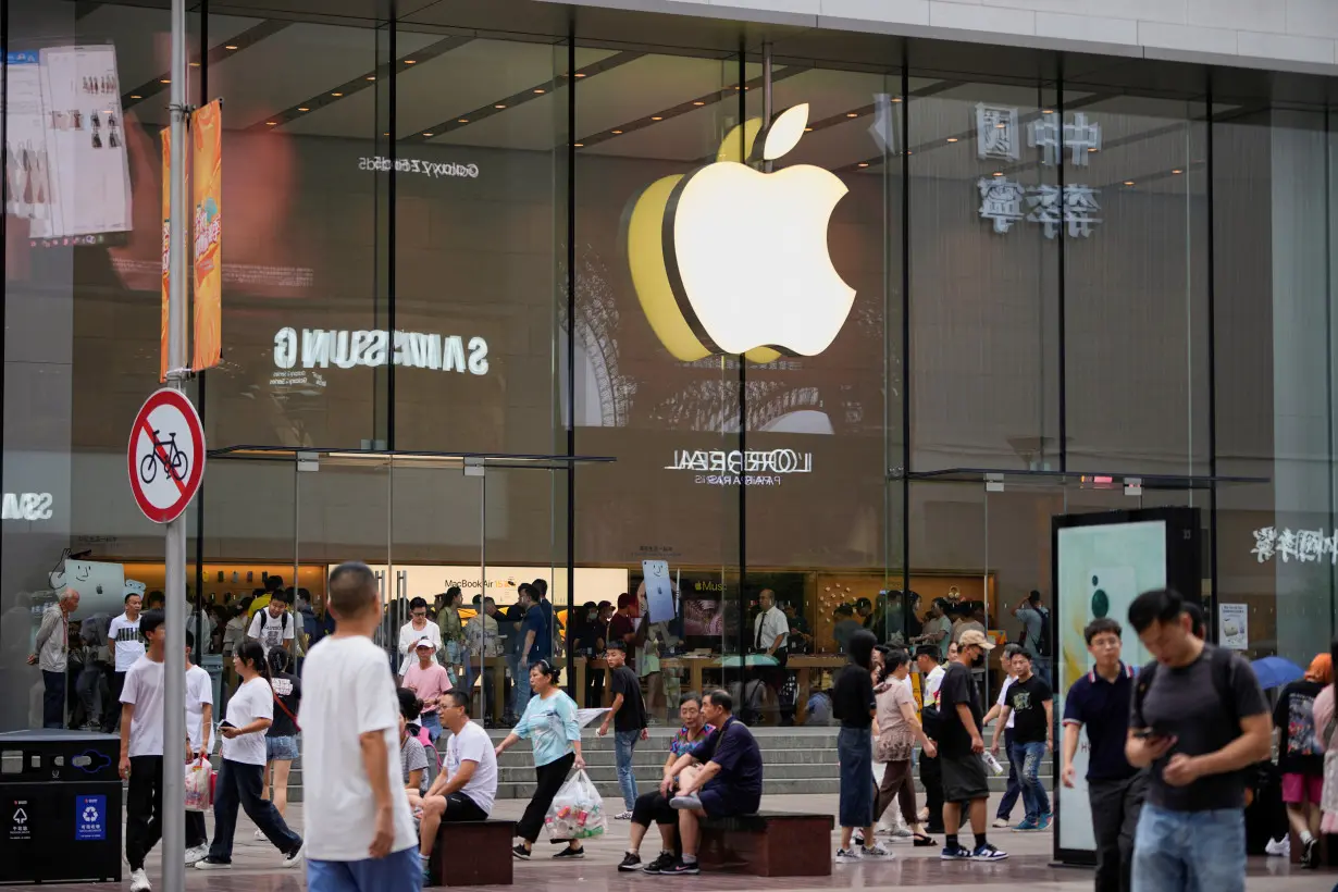 FILE PHOTO: People walk past an Apple store in Shanghai