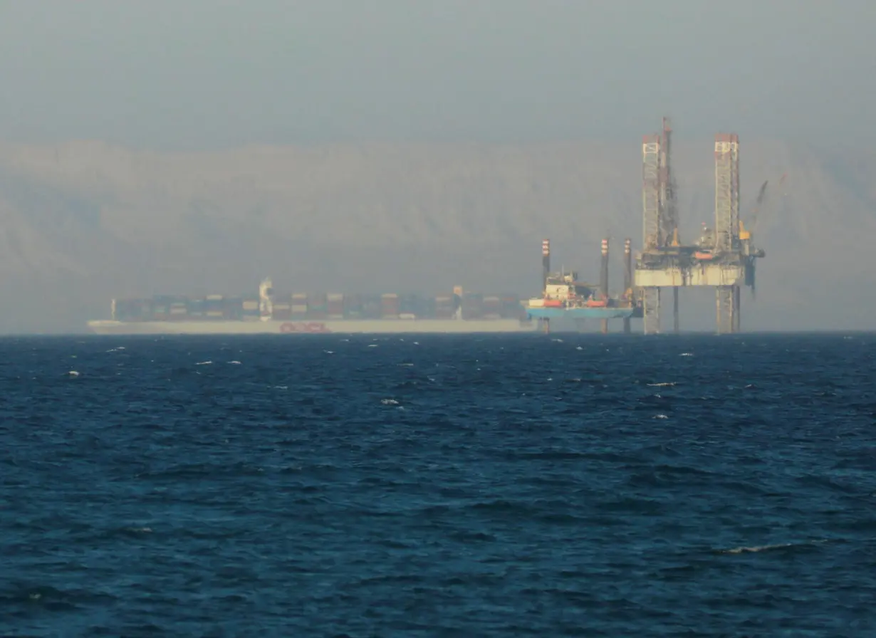 FILE PHOTO: Container ship crosses an oil platform at the Gulf of Suez towards the Red Sea