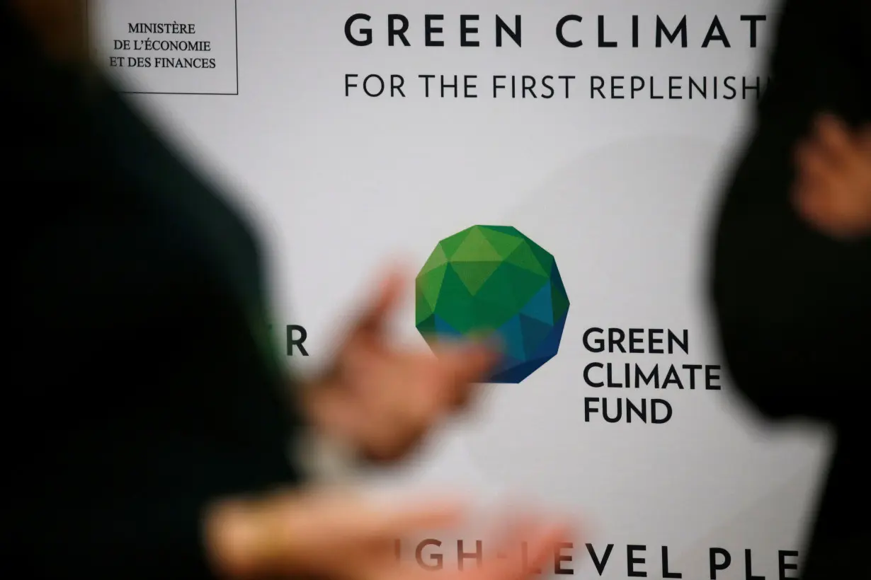 People arrive to attend the Pledging Conference of the Green Climate Fund (GCF) for the First Replenishment in Paris