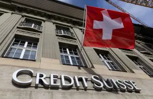 FILE PHOTO: A Swiss flag is pictured above a logo of Swiss bank Credit Suisse in Bern