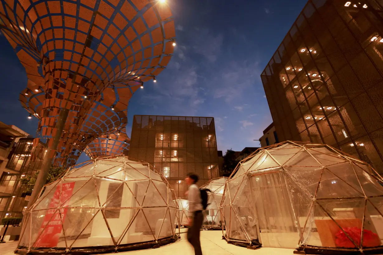 FILE PHOTO: A man walks past a pollution pod designed to mimic the air quality in New Delhi, during the United Nations Climate Change Conference (COP28), in Dubai