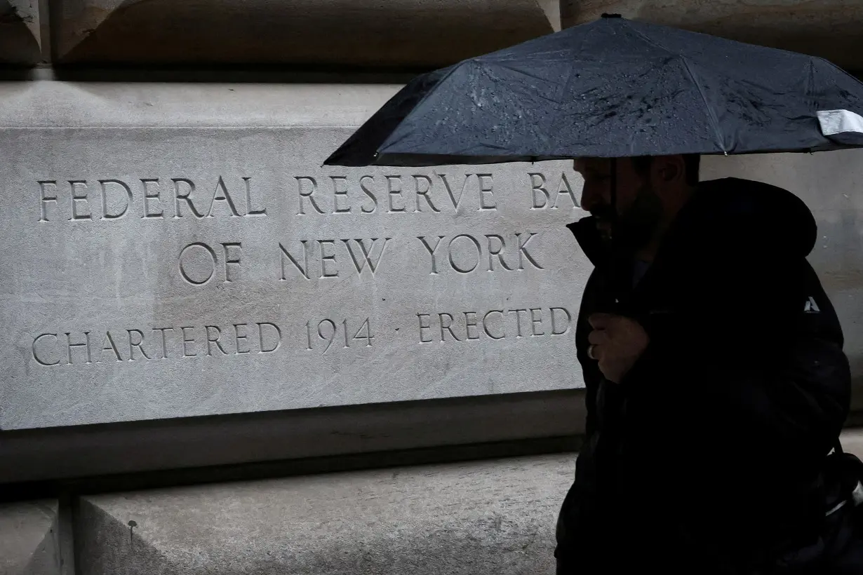 FILE PHOTO: A man passes by The Federal Reserve Bank of New York in New York