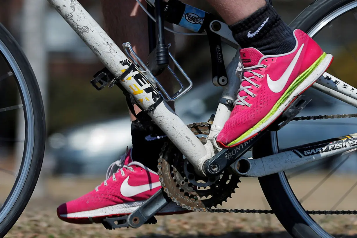 FILE PHOTO: A bicyclist wearing Nike shoes rides in Cambridge