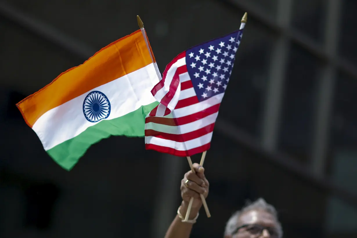 Man holds the flags while people take part in the 35th India Day Parade in New York