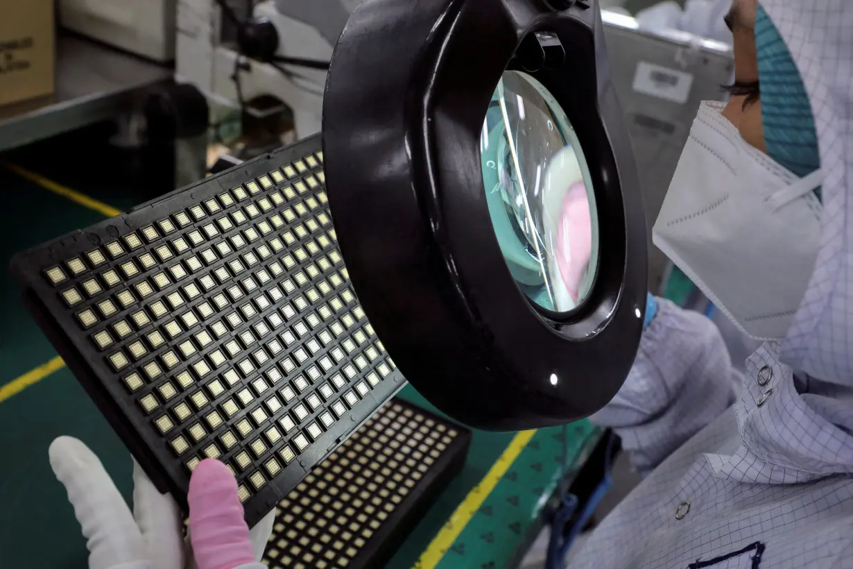 FILE PHOTO: A worker inspects semiconductor chips at the chip packaging firm Unisem (M) Berhad plant in Ipoh