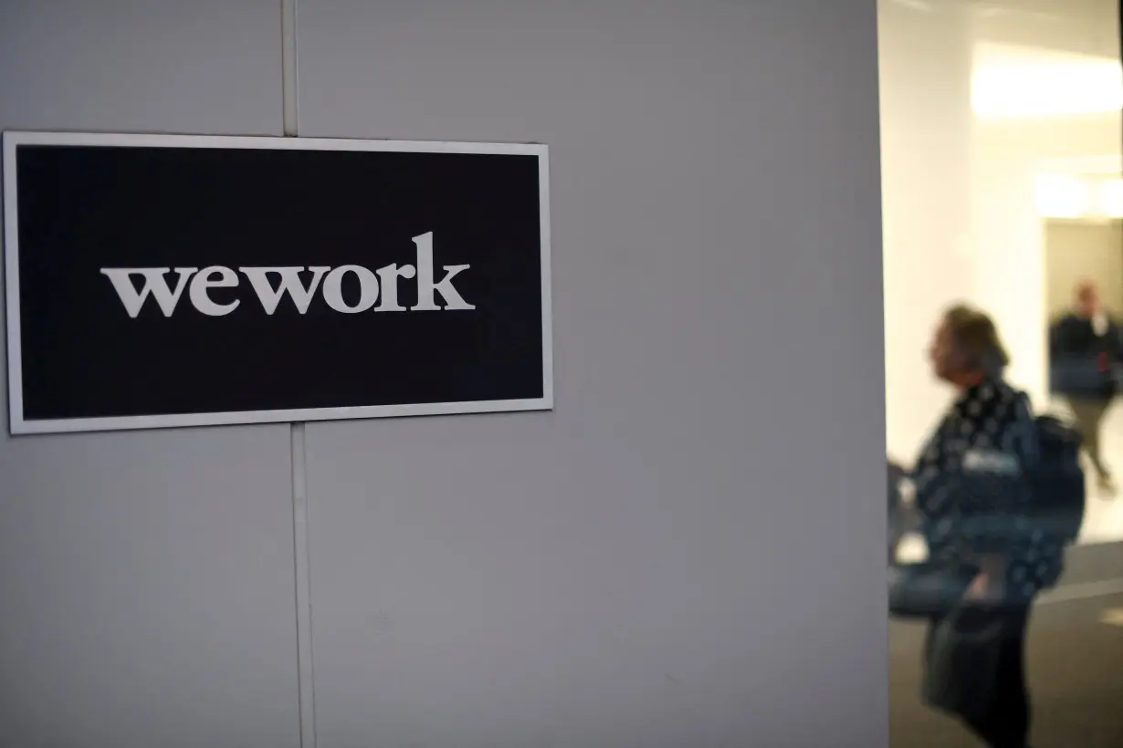 FILE PHOTO: A man and woman walk inside offices run by WeWork in Philadelphia