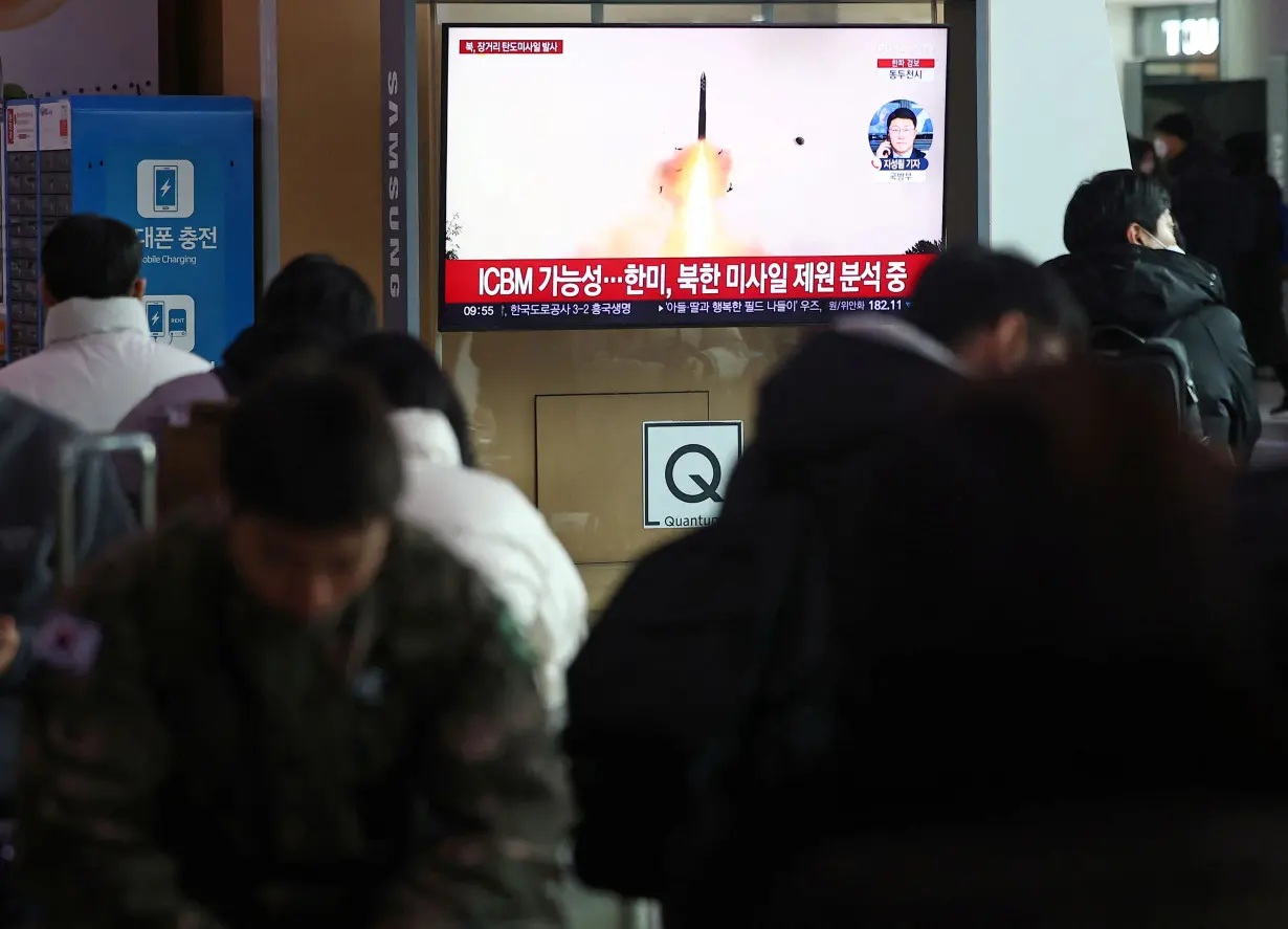 People watch a TV broadcasting a news report on North Korea firing what appeared to be a long-range ballistic missile, at a railway station in Seoul