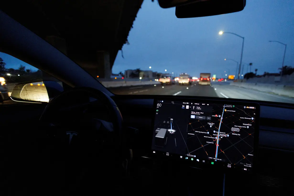 FILE PHOTO: Tesla Model 3 drives on autopilot along California freeway