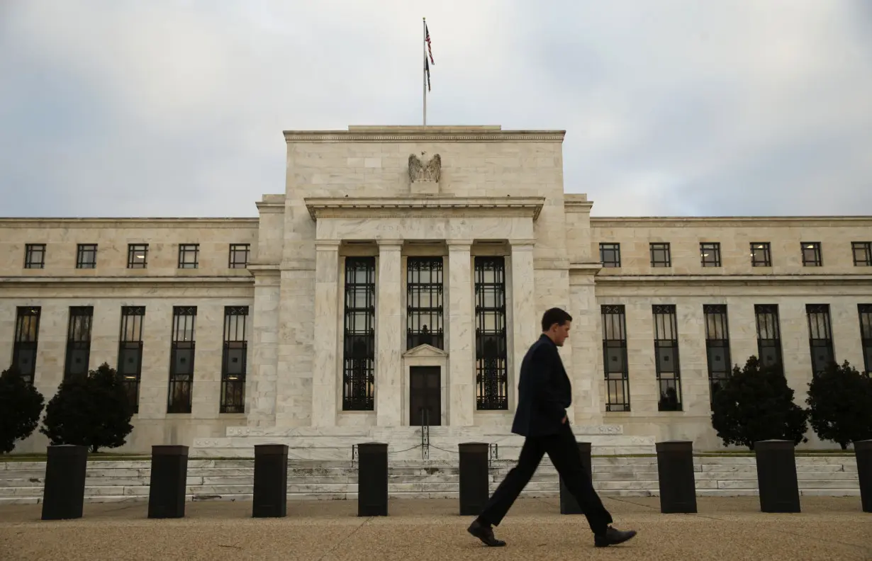 A man walks past the Federal Reserve in Washington