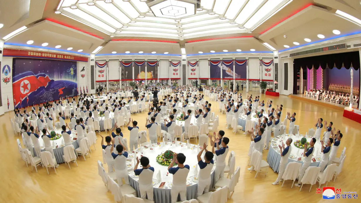 North Korea's leader Kim Jong-un attends a banquet to celebrate the launch of a reconnaissance satellite