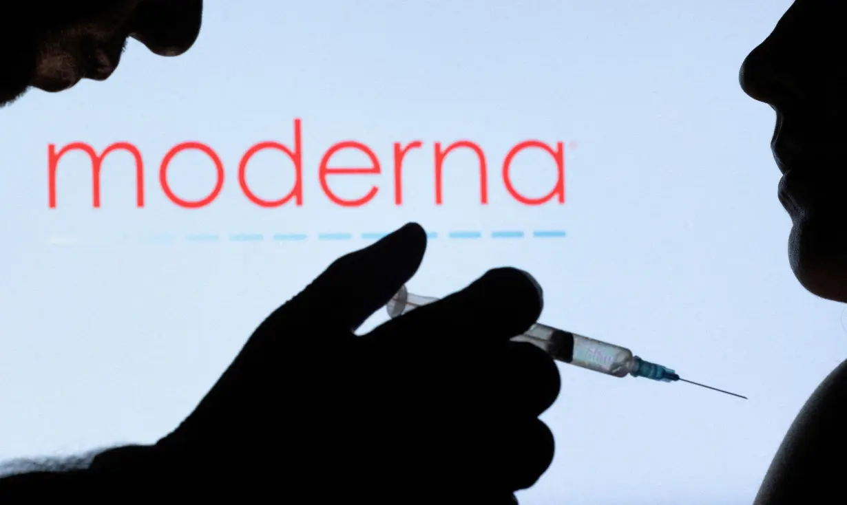 FILE PHOTO: People pose with syringe with needle in front of displayed Moderna logo