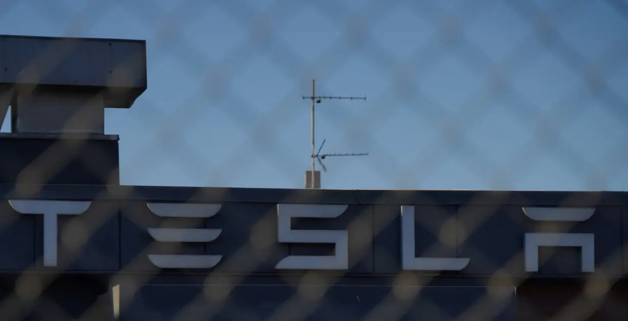 FILE PHOTO: A Tesla sign is displayed over a Tesla showroom in Malmo