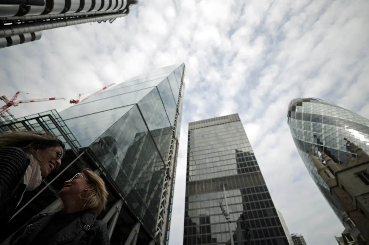 FILE PHOTO: People walk through the City of London financial district in London